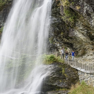 Spaziergang hinter dem Wasserfall Steinsdalsfossen - Die große Wasserfall- und Fjordtour, Hardangerfjord, Norwegen
